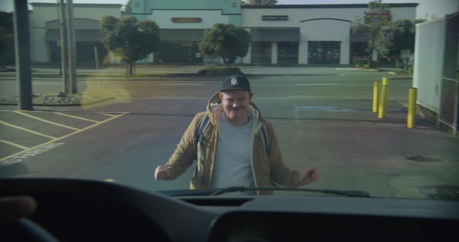 A vehicle stops as a man dances in front of it