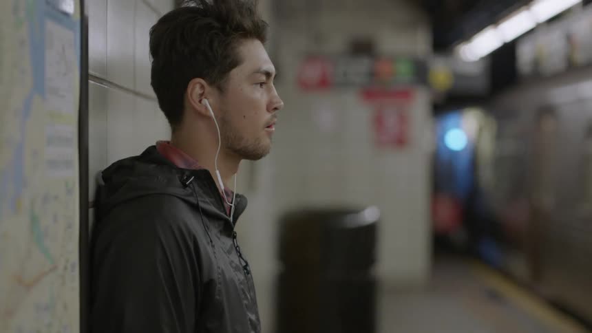 Man watching a subway go by in a subway station