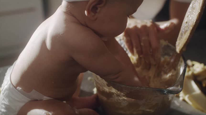A man is cooking with a baby