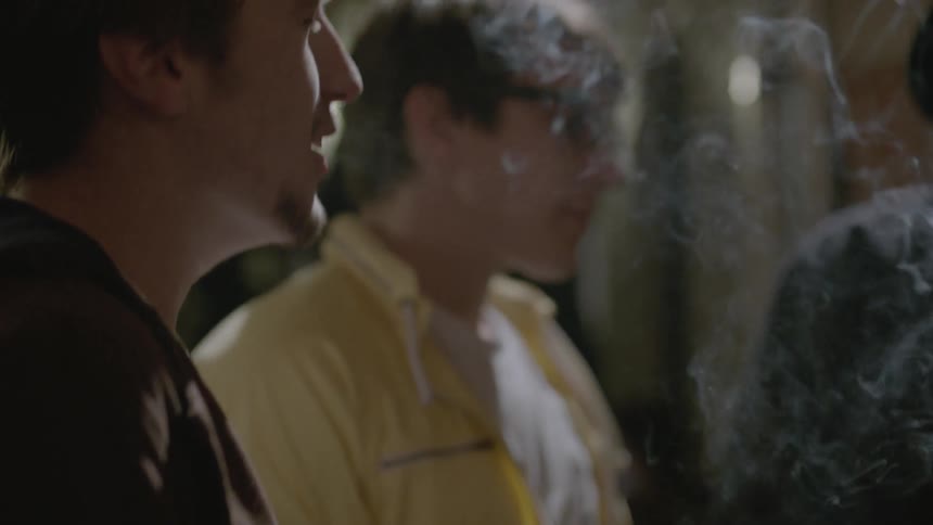 A group of men talk, smoke and drink beers