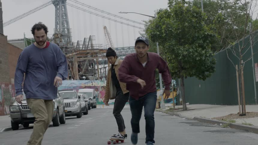A group of people are skateboarding together on a street