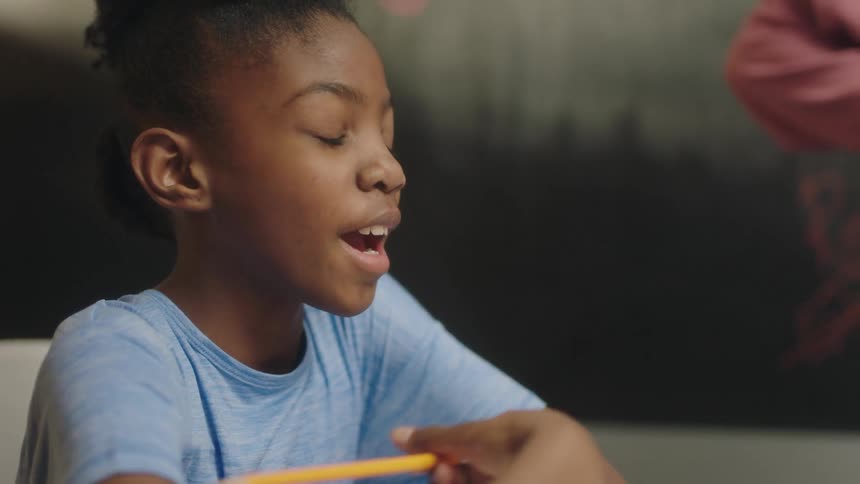 A girl speaks while sitting in a classroom