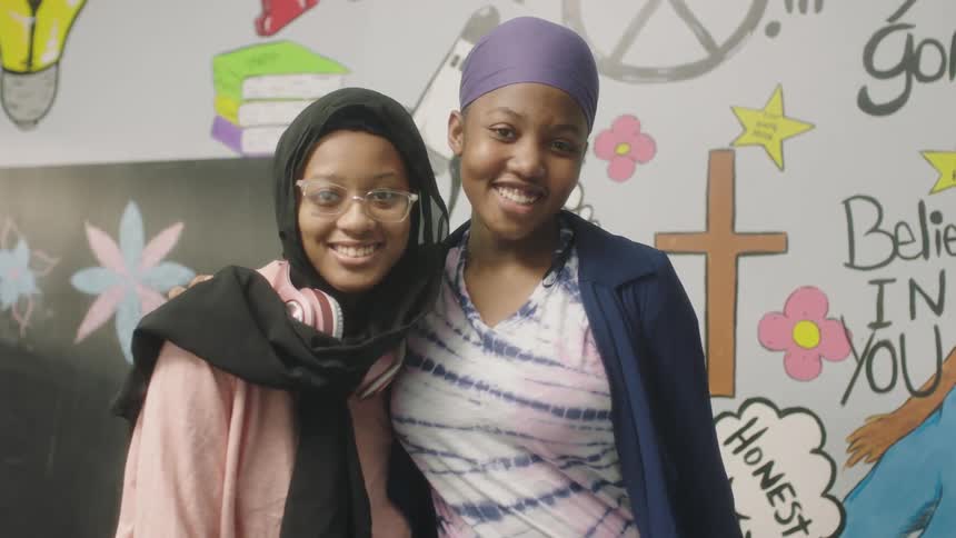 Two girls pose in the classroom