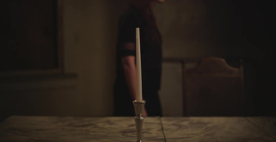 A woman places a candle on a table