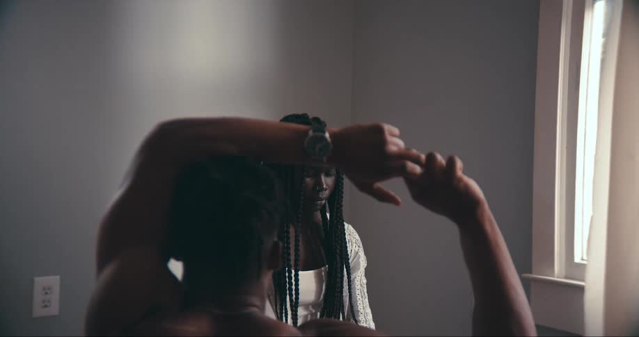 A woman looks at then averts her gaze from a man who is stretching his arms over his head