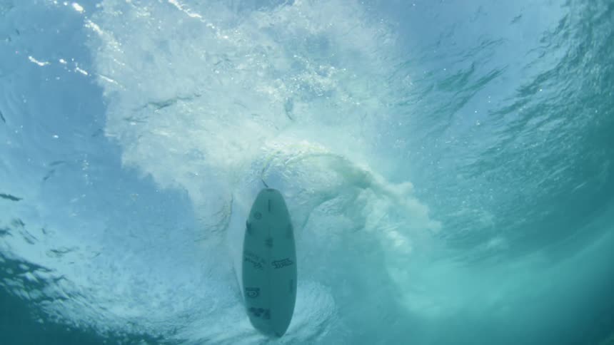 underwater view of a surfer riding a wave