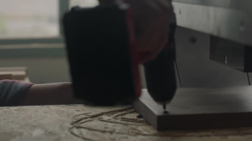 Person using a power drill to secure screws