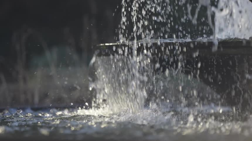 Water gushes and splashes from a fountain in the park
