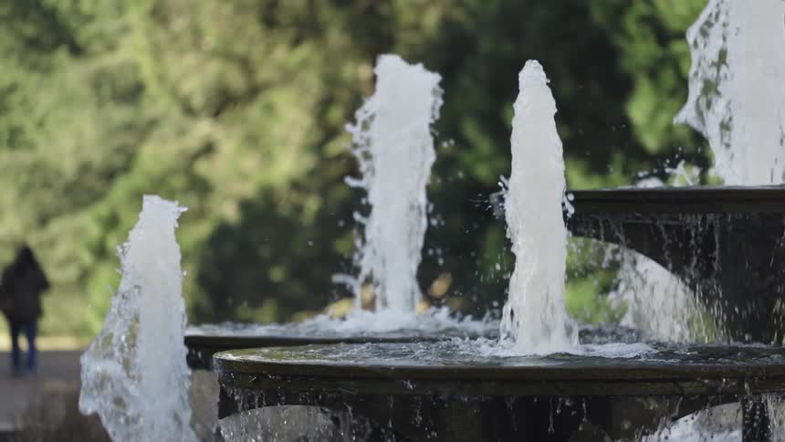 Fountains in a park are shooting water into the air and splashing