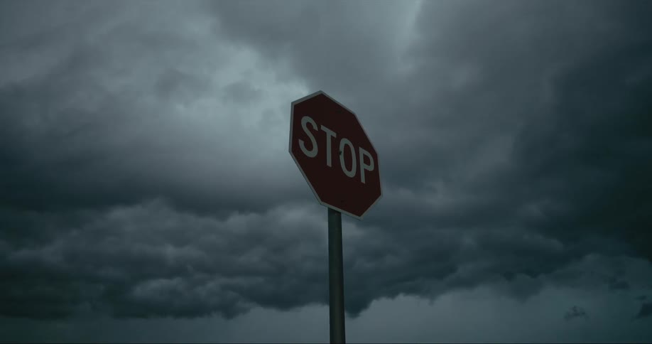 Storm clouds gathering above a stop sign
