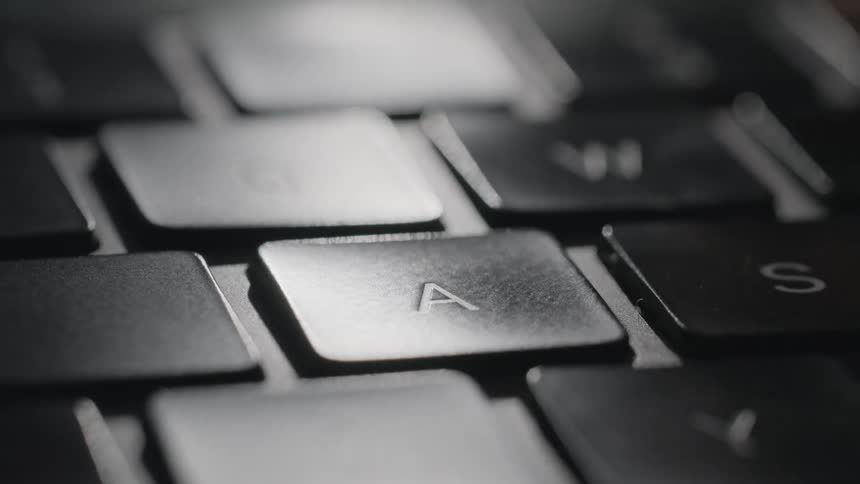A person presses the a button on a keyboard