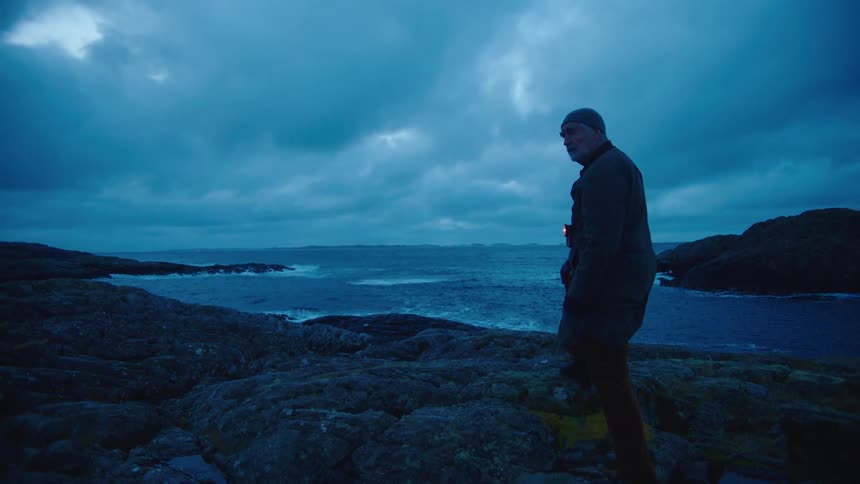 Old man walking towards sea