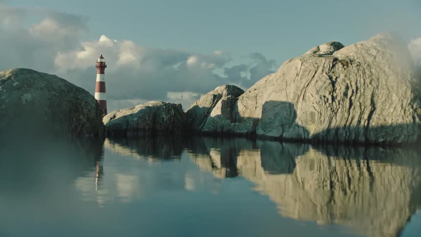 Boulders near a lighthouse on the ocean during the day