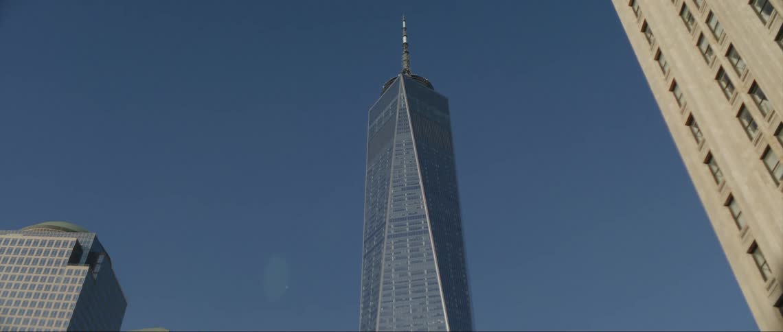 A skyscraper looms of a metropolis on a clear day