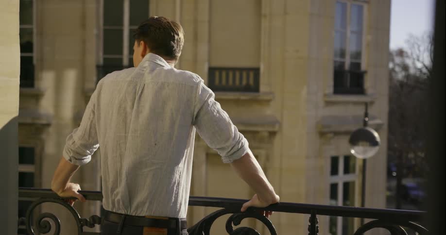 Man standing at a railing of a balcony