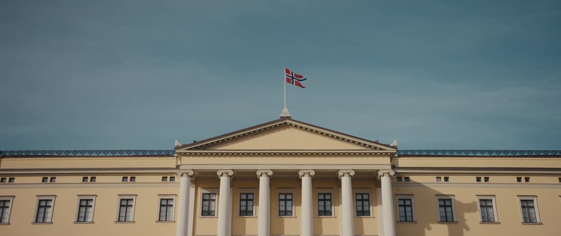 View of the flag of Norway flying proudly above The Royal Palace, residence of the monarch, in Oslo, Norway