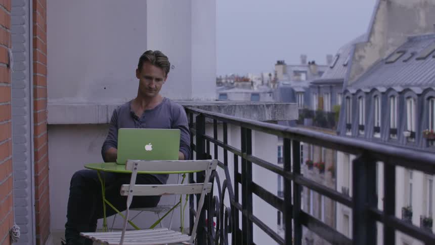 Person using a laptop while sitting on a terrace