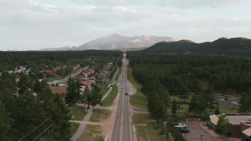Cars drive on the road in the small town