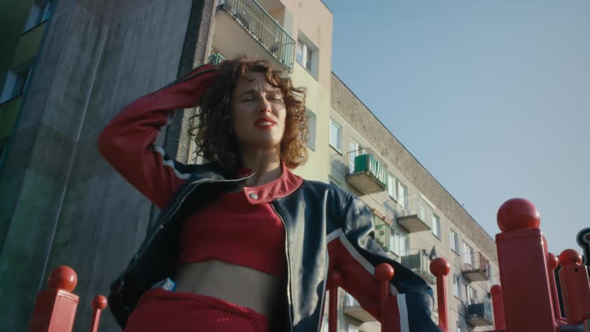A woman poses by the apartment building