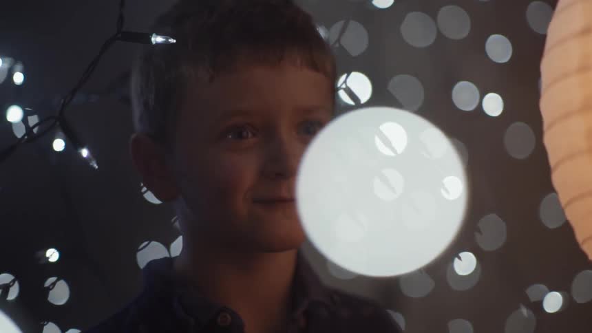 A child surrounded by string lights