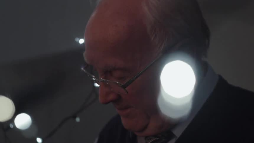 A man looks down with lights surrounding him