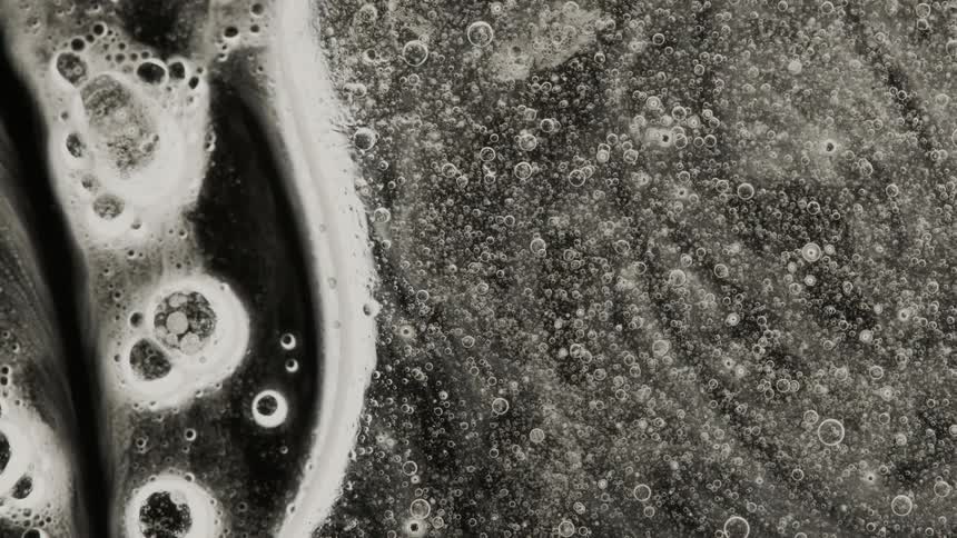 Liquid with bubbles flowing on dark background