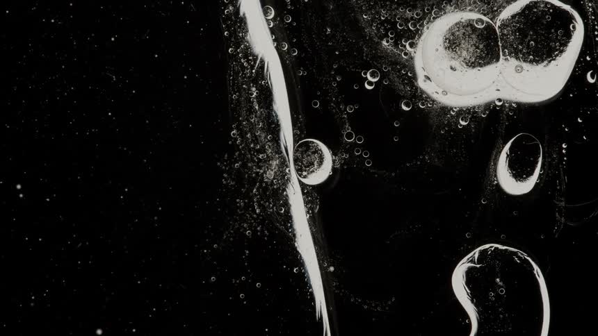 Liquid with bubbles flowing on dark background