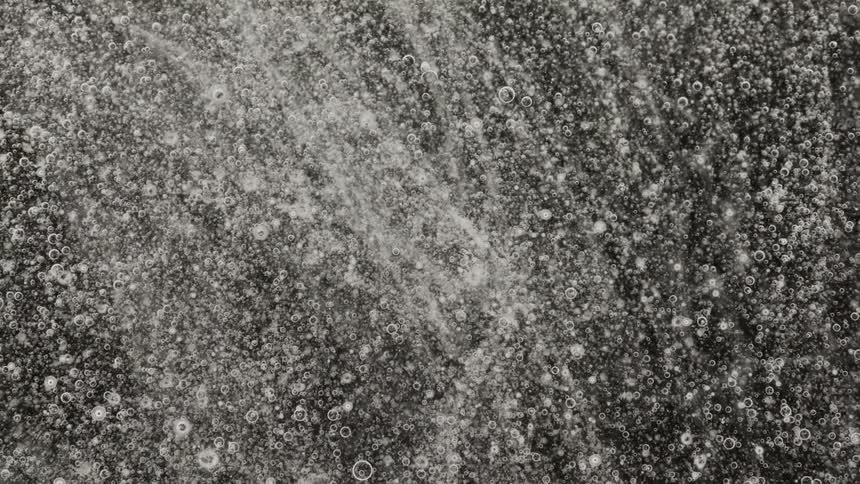 Small bubbles with white outlines are floating outward