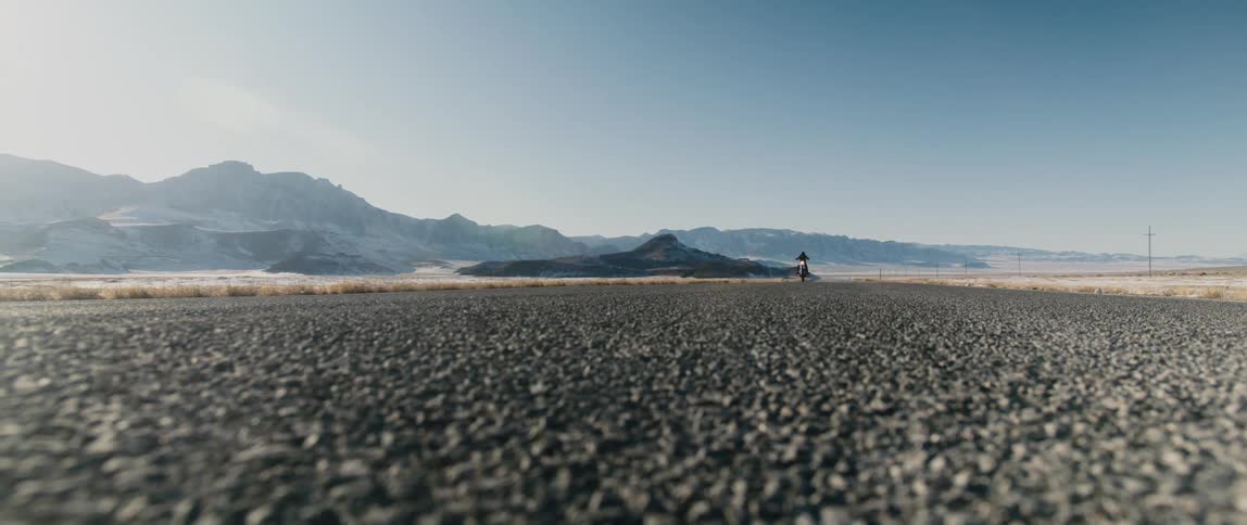 Biker rides motorcycle on tarmac highway at high speed