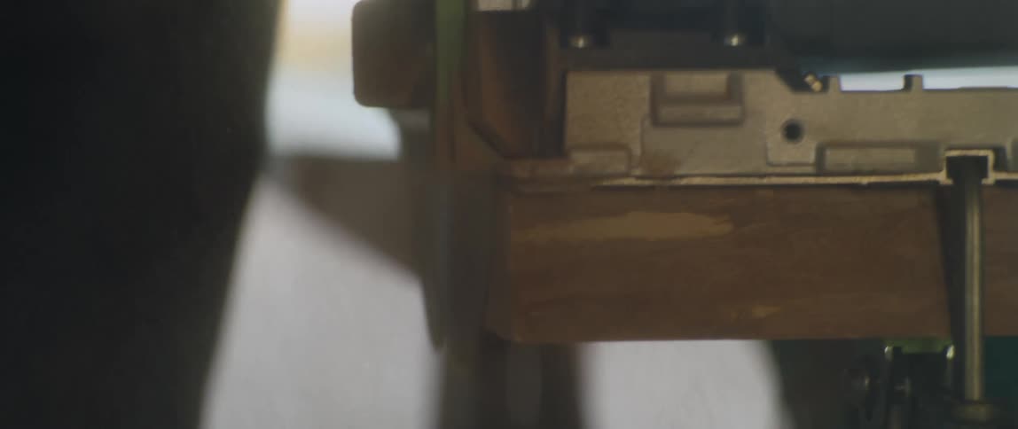 A saw is used to cut the edge of a large slab of wood