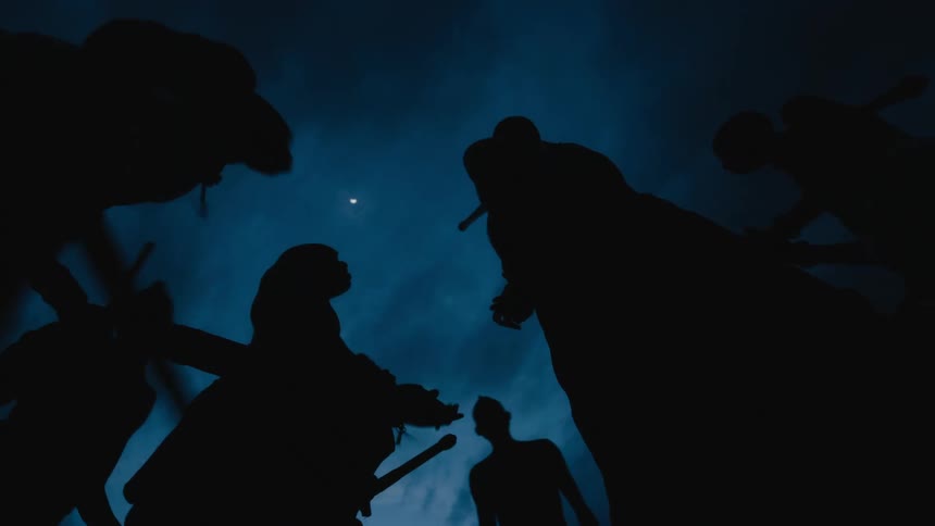 African tribesmen performing ritual dance are silhouetted against the dark clouds and moon