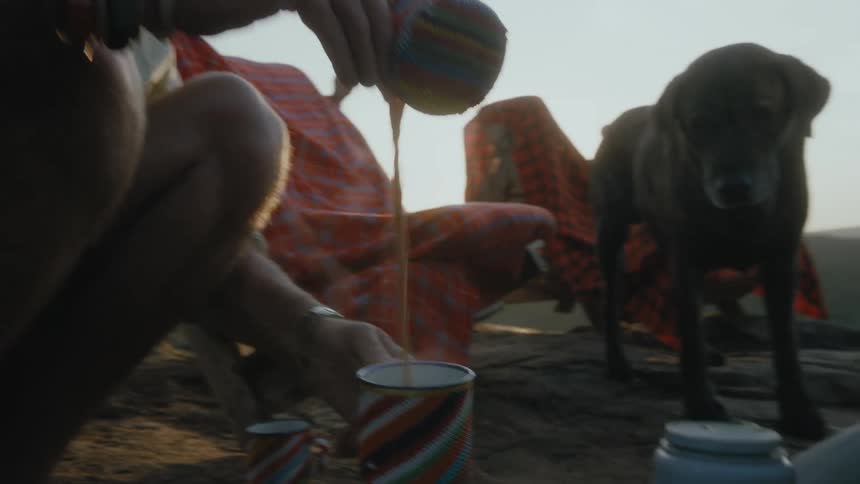 People are making drinks while camping outdoors