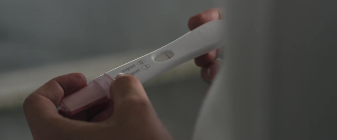 Womans hands holding a pregnancy test