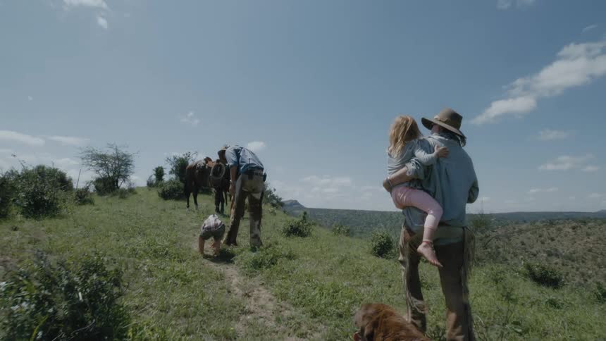 A family hikes with their dog through rural fields