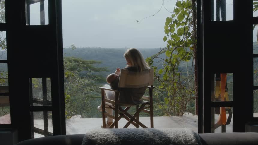 A mother holds her baby on the porch