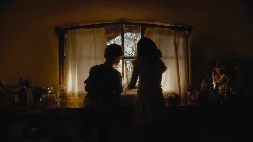 Boy and girl brushing teeths together in front of a sink in front of a window