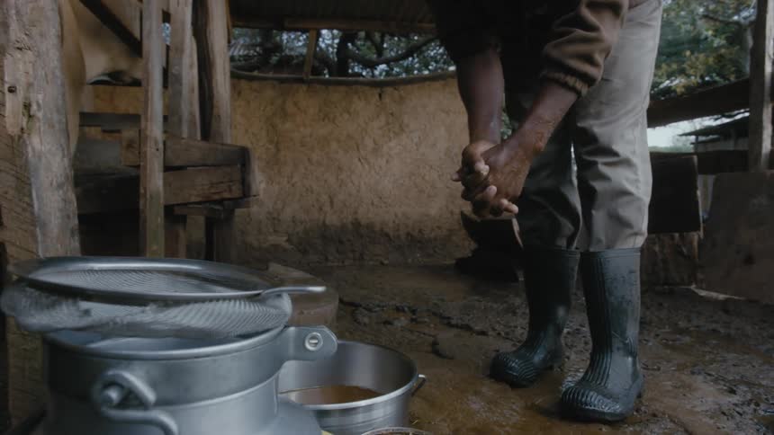 A ranch worker cleans his hands in the stable