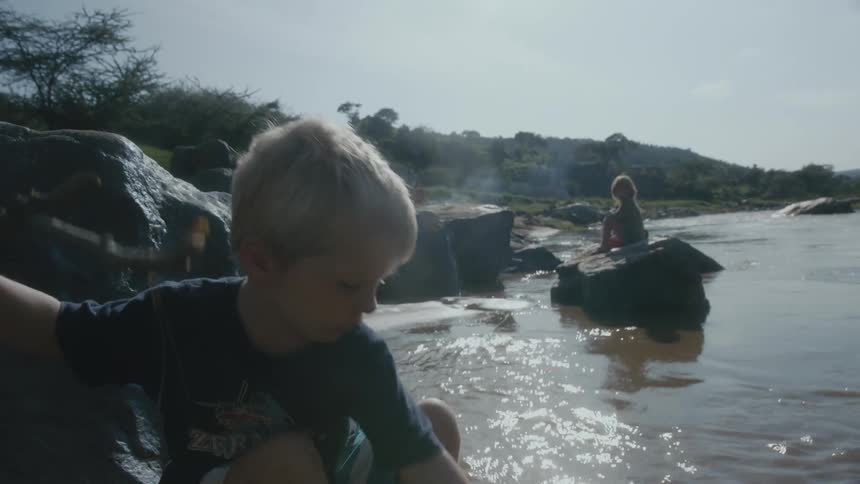 Two children are playing by a river in spring