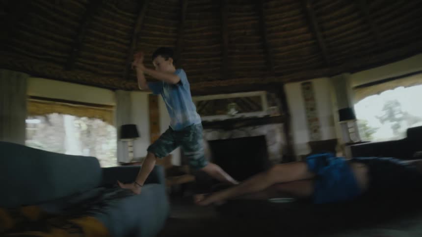 Two children jump around on the bed