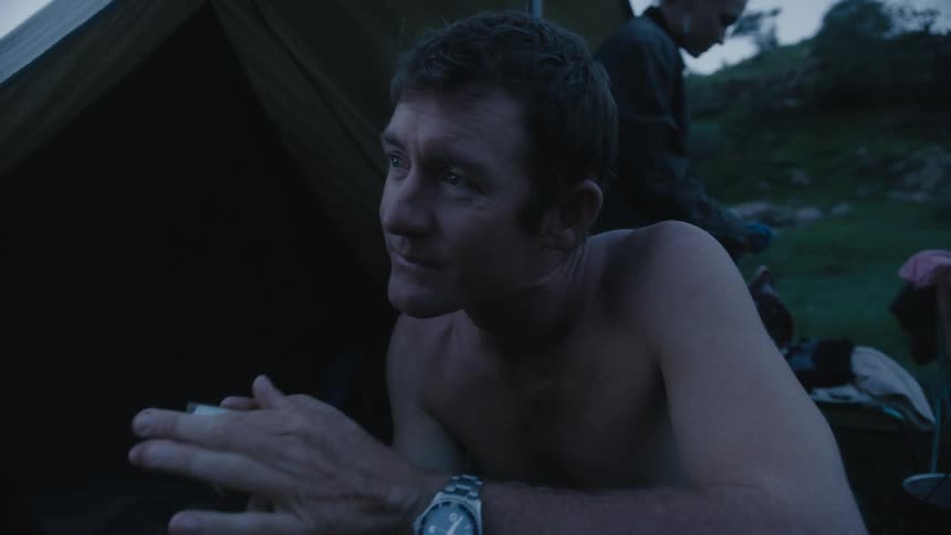 A group of people are camping outdoors in the wilderness