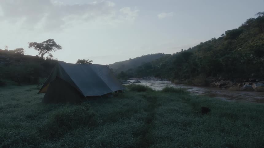 A tent is set by the stream