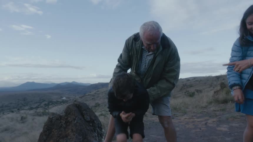 Grandfather lifting up his crying grandson from the ground and stroking his back
