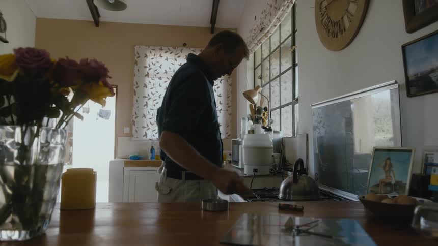 Father holding baby while taking tea kettle to heat on stove