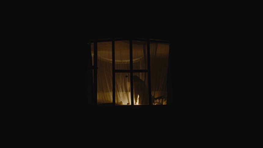 A woman is walking around her room at night