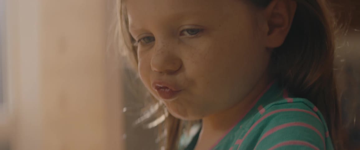 A young child plays with toys while making noises with her mouth