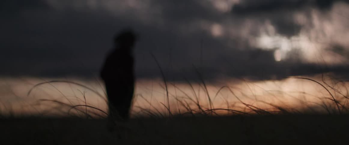 A silhouette of a man standing outdoors
