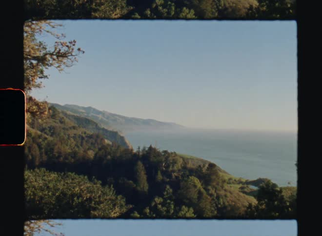 A mountain slope covered in thick forest leading down to the ocean Big Sur California Super8 4k Film Scan
