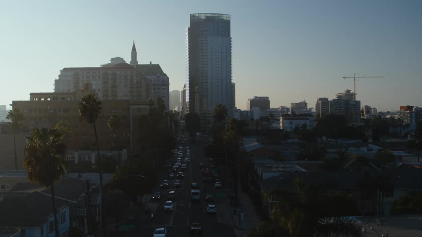 An aerial view of cars driving on a city street with office buildings