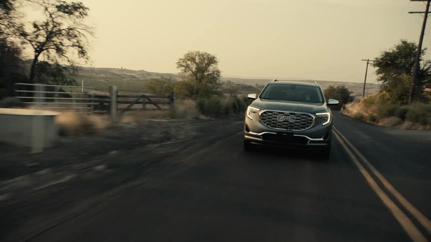 A car is driving up the road