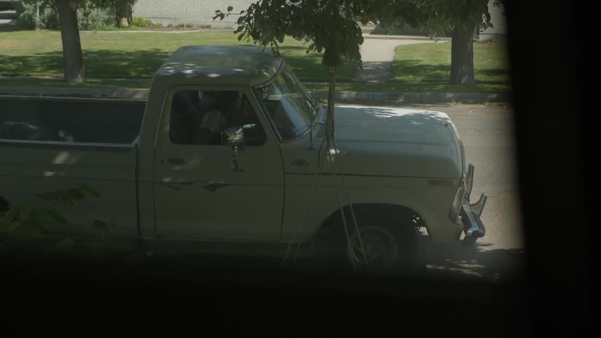 A man and woman run to a pickup truck and drive off watched through a window